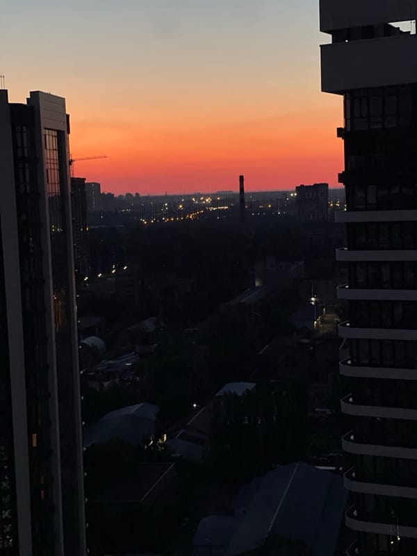 Balcony hangout at dusk above Kyiv's residential skyline