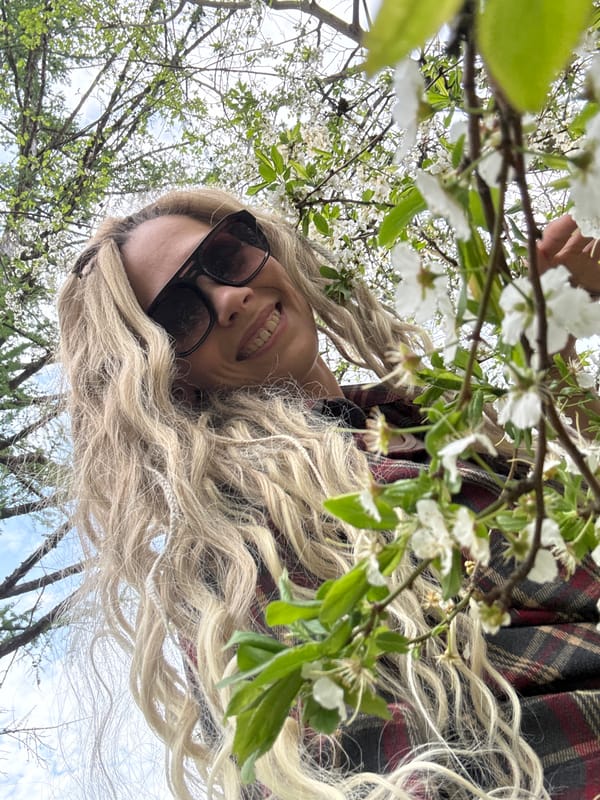 Woman poses for photos amid spring blossoms in Rusanovo
