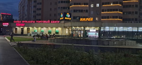 Dusk to night across a Kazakh city's commercial streets and landmarks
