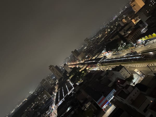 Late-night beer drinking overlooking São Paulo cityscape captured