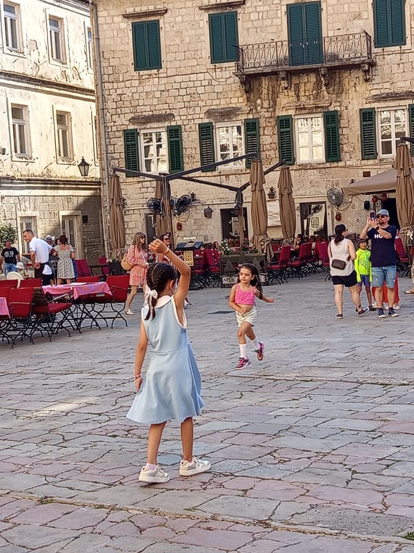 Kotor's old town square buzzing on a sunny afternoon