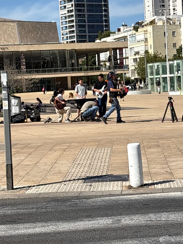 Street musicians perform in Tel Aviv plaza during sunny afternoon