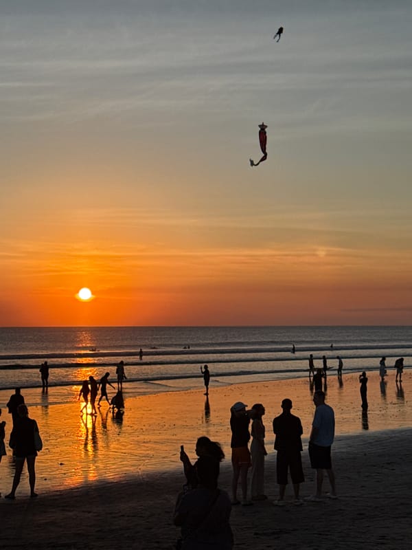 Sunset gathering draws photographers and walkers to Kuta Beach
