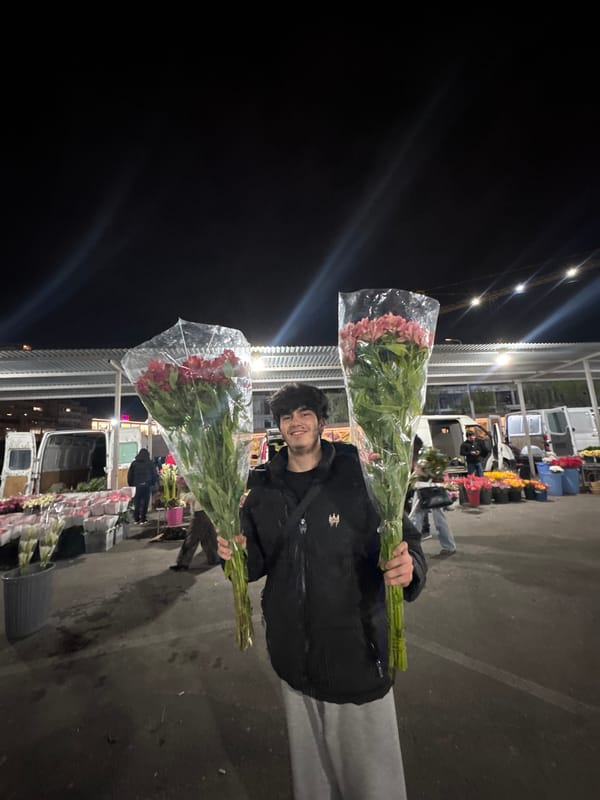 Person buys flowers at nighttime Yerevan market