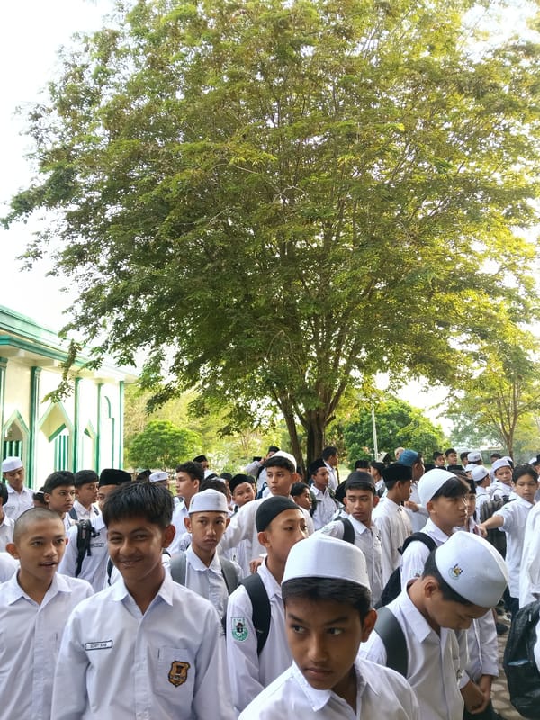 Male students gather outdoors in Lhokseumawe, Indonesia