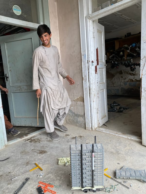 Men repair hybrid car batteries in Kandahar workshops