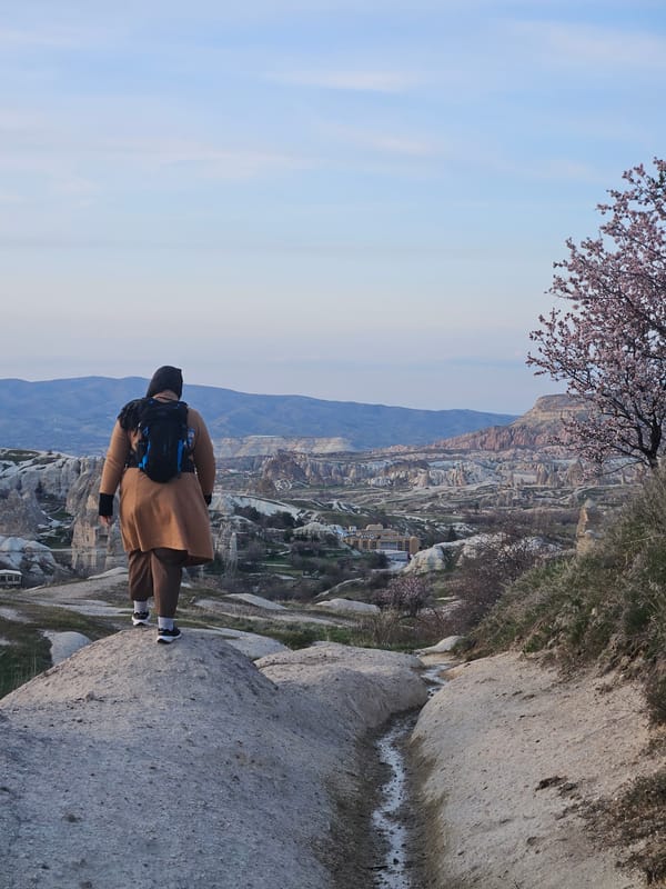 Man stands on rock formation in Cappadocia, Turkey