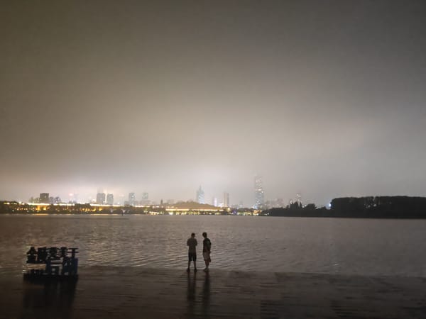 Night at Xuanwu Lake: waterfront calm and a winged statue