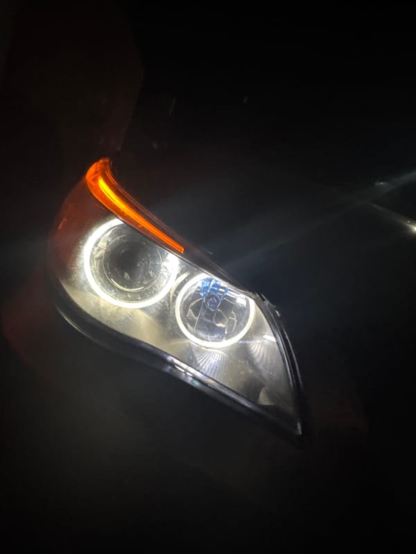 BMW with illuminated headlights parked in Bulgarian village