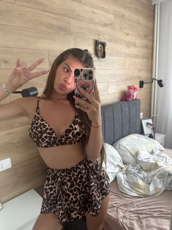Woman takes leopard-print outfit selfies in bedroom setting