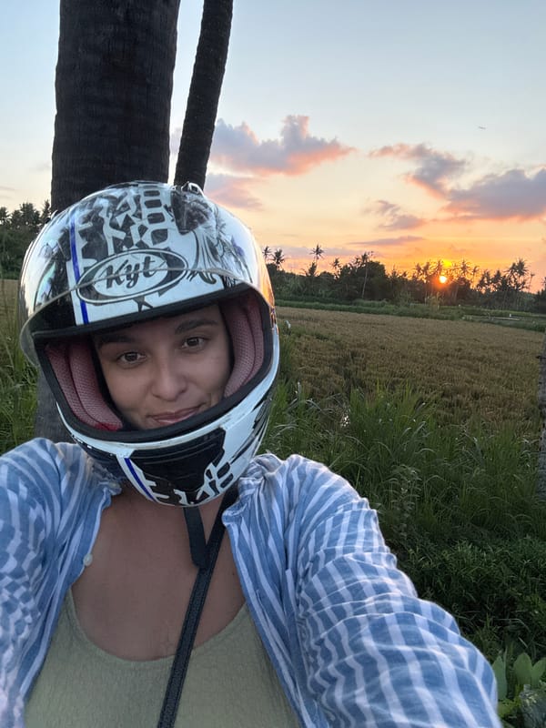 Motorcyclist poses during scenic sunset in Pering rice fields