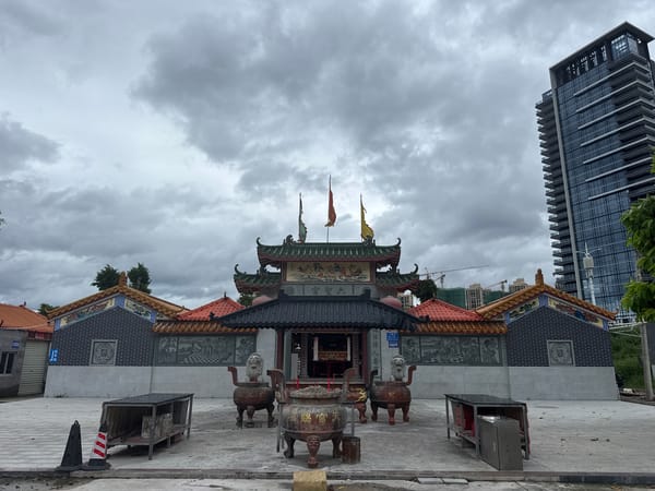 Traditional temple complex in Huizhou, framed by modern city