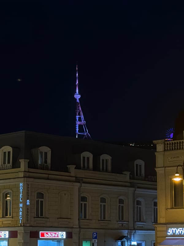 Evening scenes captured across Tbilisi featuring illuminated landmarks, vintage cars