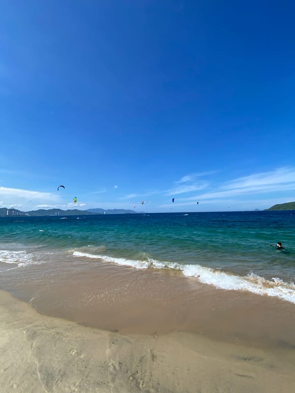 Kiteboarders and calm shores at Nha Trang beach