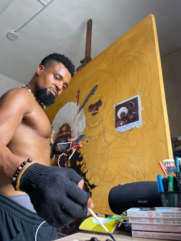 Artist captured working in studio wearing traditional beads in Ado