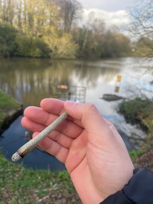 Person smokes marijuana joint by waterway in Salford