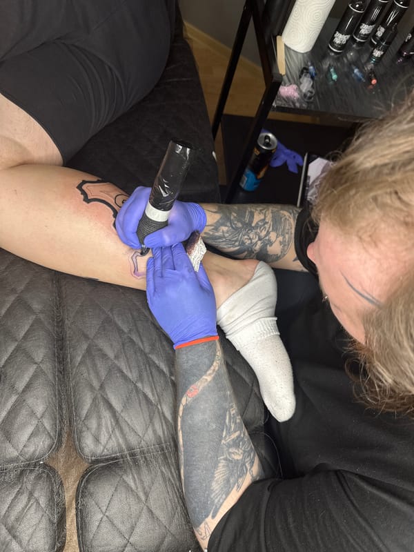 Tattoo session featuring horse-drawn carriage design captured in Saratov