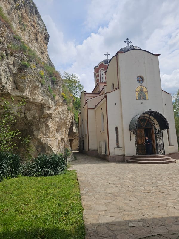 Visitor documents historic cliff monastery in Basarbovo, Bulgaria