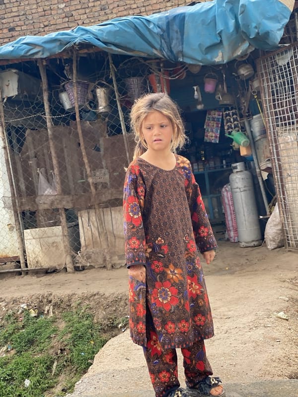Children navigate muddy Kandahar streets after morning rain