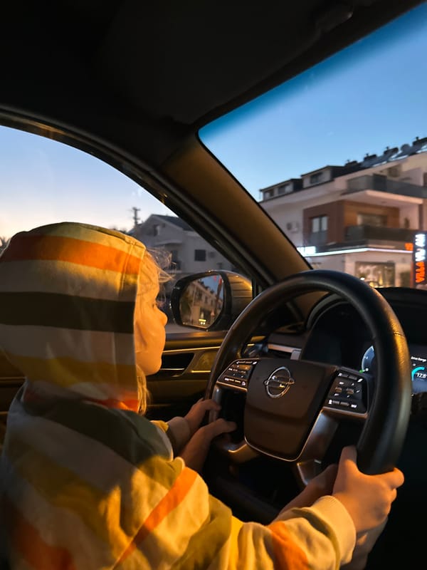 Child in striped sweater photographed inside car in Fethiye