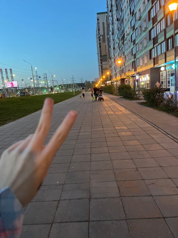 Modern residential building observed along gray stone pedestrian walkway