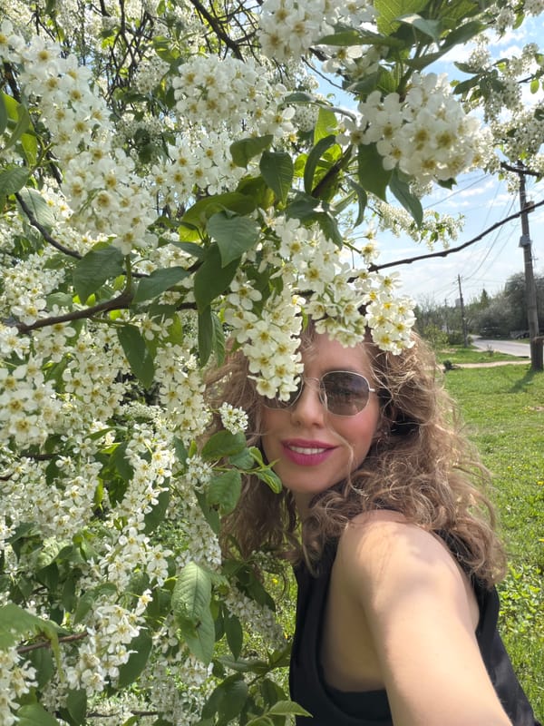 Woman photographs spring blossoms in sunny outdoor setting