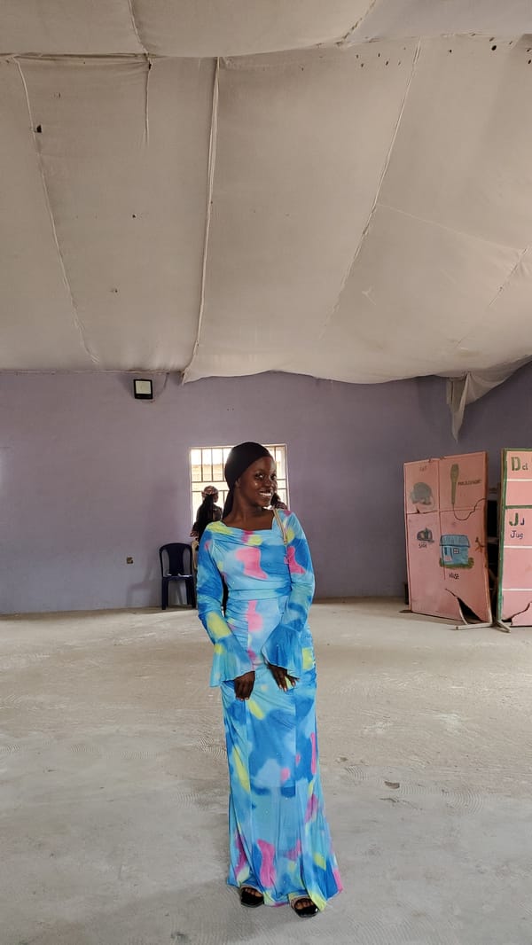 Indoor gathering in Jalingo community hall, colorful dress on display