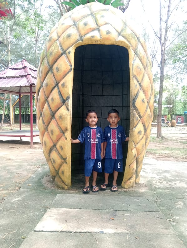 Boys in PSG jerseys pose inside pineapple structure Indonesia
