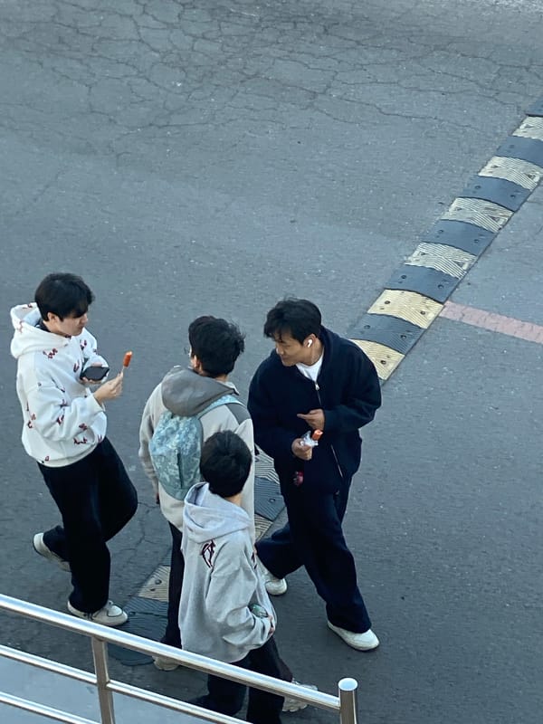 Pedestrians walk near sports field and construction site in Zhongtun