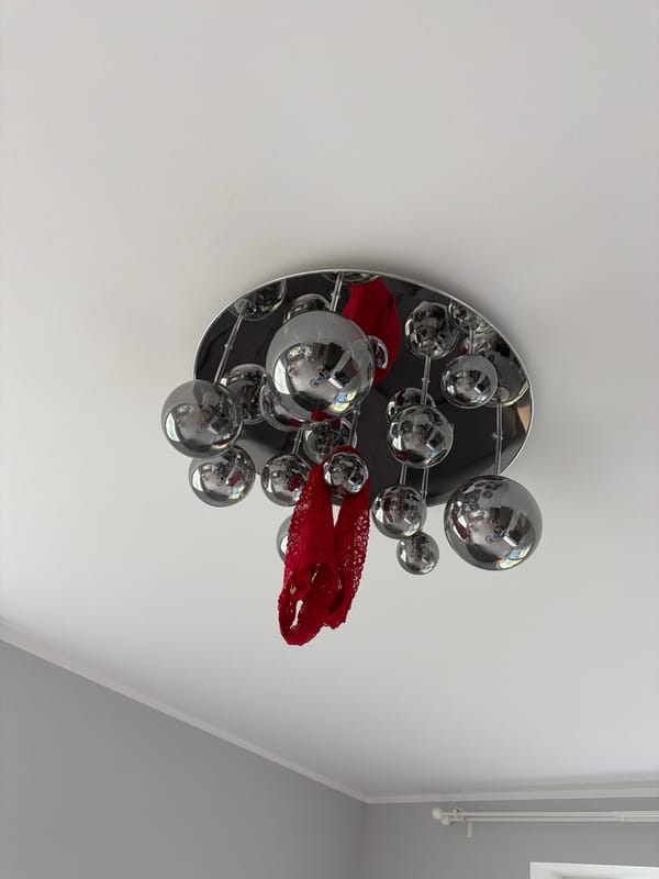 Red lace adorns chrome light fixture in Latvia