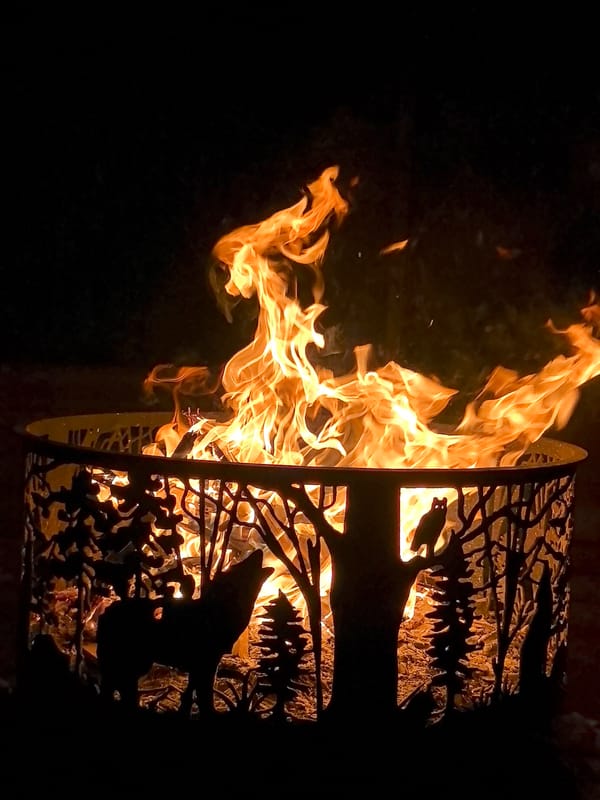 Decorative wolf silhouette fire pit burning at night, Kazakhstan