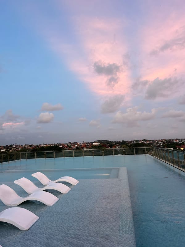 Rooftop pool and illuminated fountain captured at North Kuta sunset