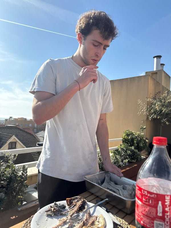 Two men share outdoor meal on Vila Nova balcony