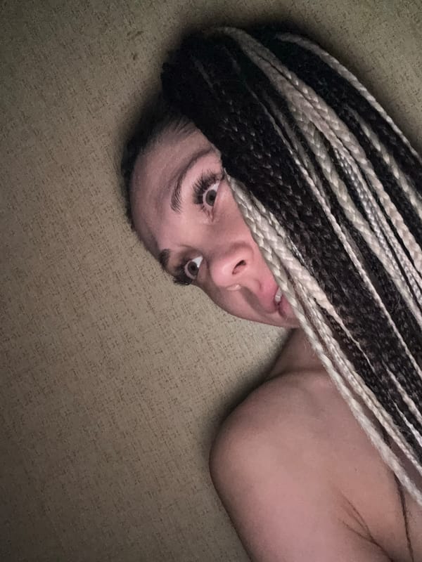 Person with braids rests on textured surface