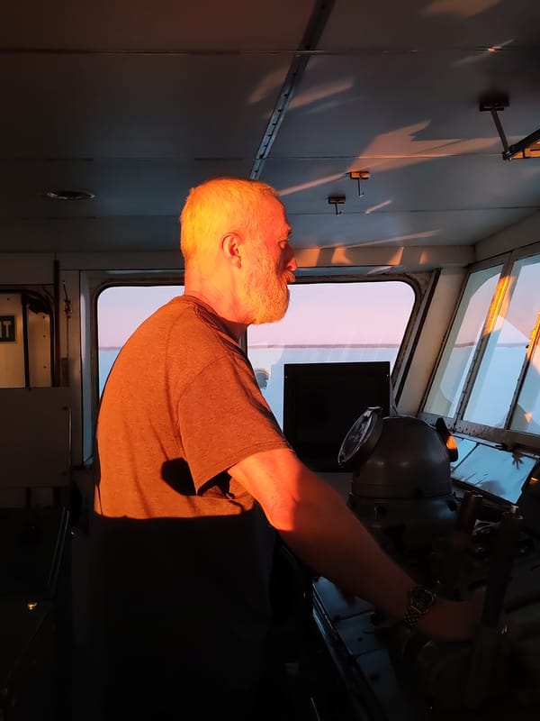 Ship captain navigates vessel near Bereg, Russia early morning