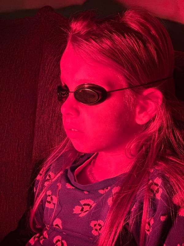 Girl receives red light therapy treatment at home