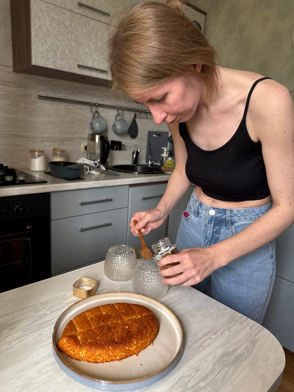Woman transfers jar contents with wooden spoon in Izhevsk kitchen