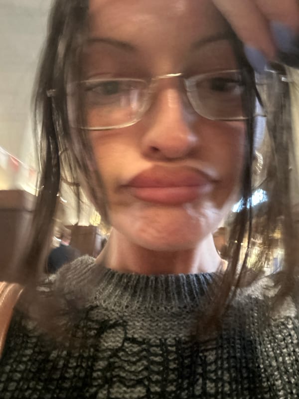 Person takes selfie indoors wearing grey sweater in London
