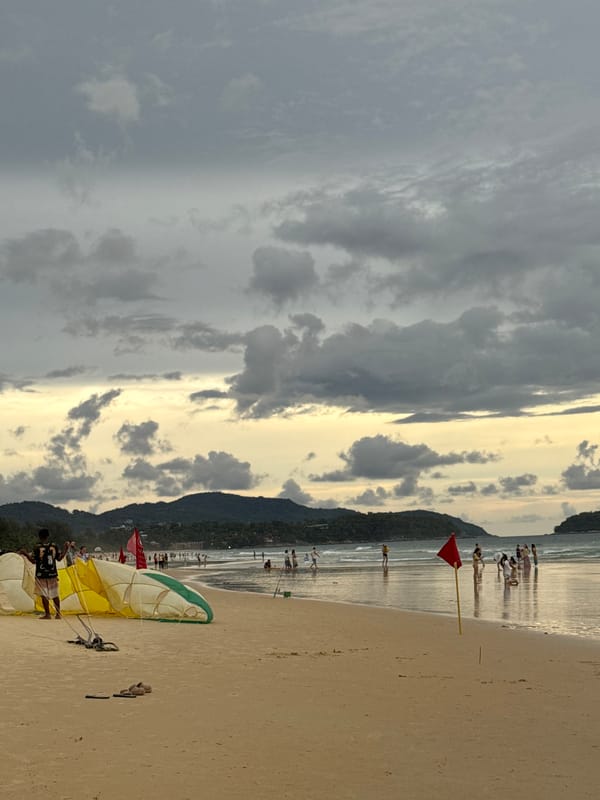 Sunset hours on Karon Beach, paragliding gear and golden skies