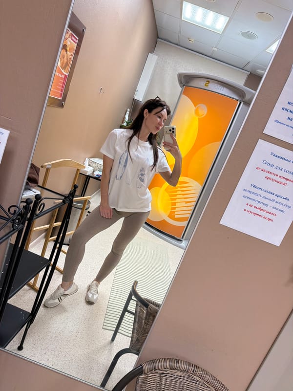 Woman takes mirror selfie at tanning studio in Perm