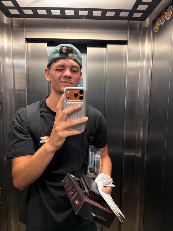 Mirror selfie in a Blagoevgrad elevator, green cap and backpack