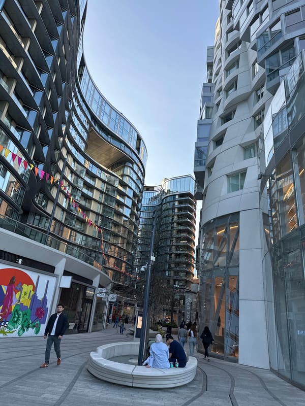Man in suit poses beside colorful mural in London