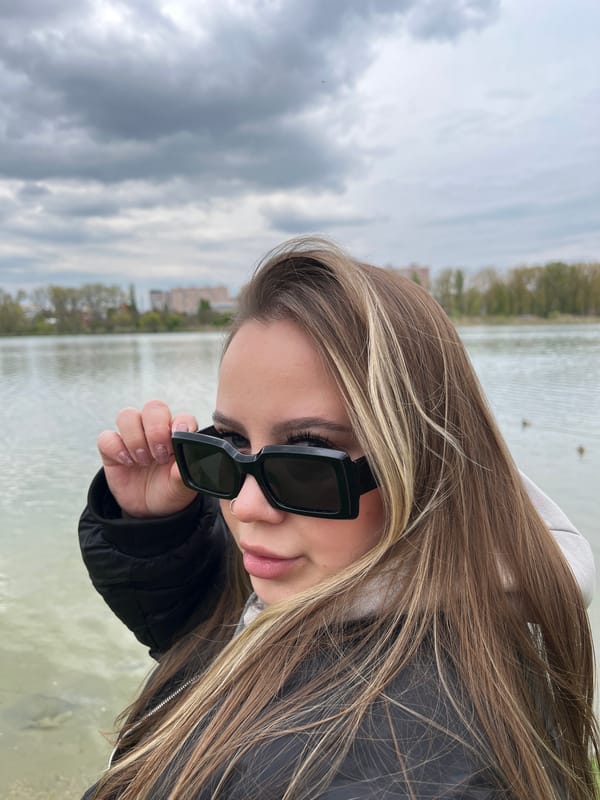 Woman documents leisurely afternoon by Krasnodar waterway, observing ducks