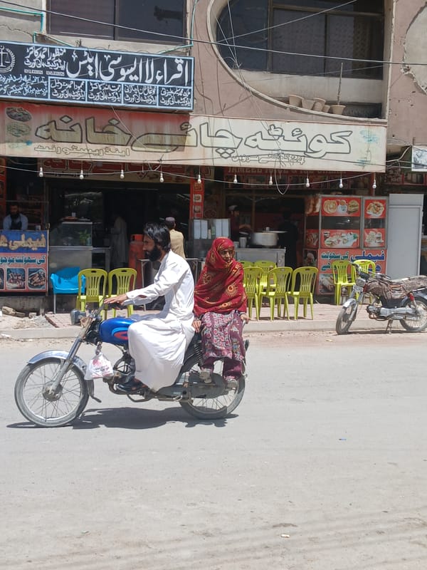 Man repairs motorcycle tire on Quetta street