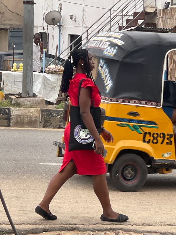 Busy Nigerian street scene with vendors, tuk-tuks, and motorcycles