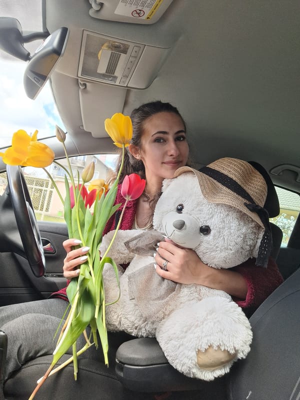 Woman with tulips and teddy bear amid spring blooms in Bulgaria