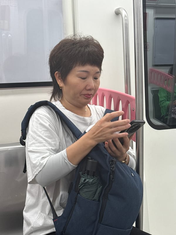Woman commutes on Longta subway with phone and backpack