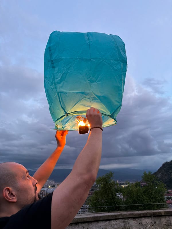 Man releases blue sky lantern at dusk in Plovdiv