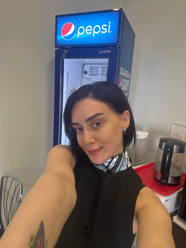 Woman takes selfies in Tbilisi kitchen with Pepsi fridge