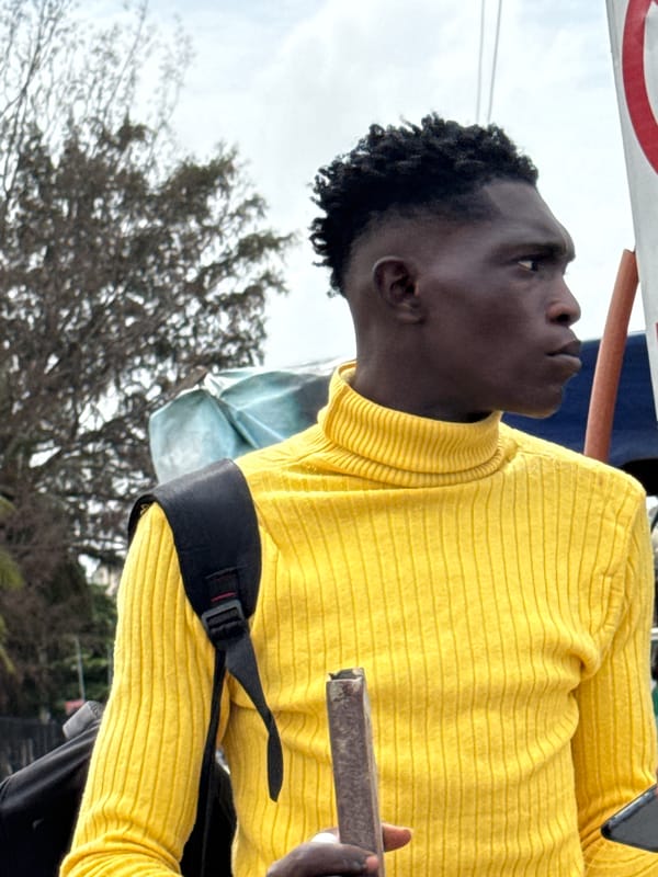 Young man observed looking upward in Nigerian marketplace